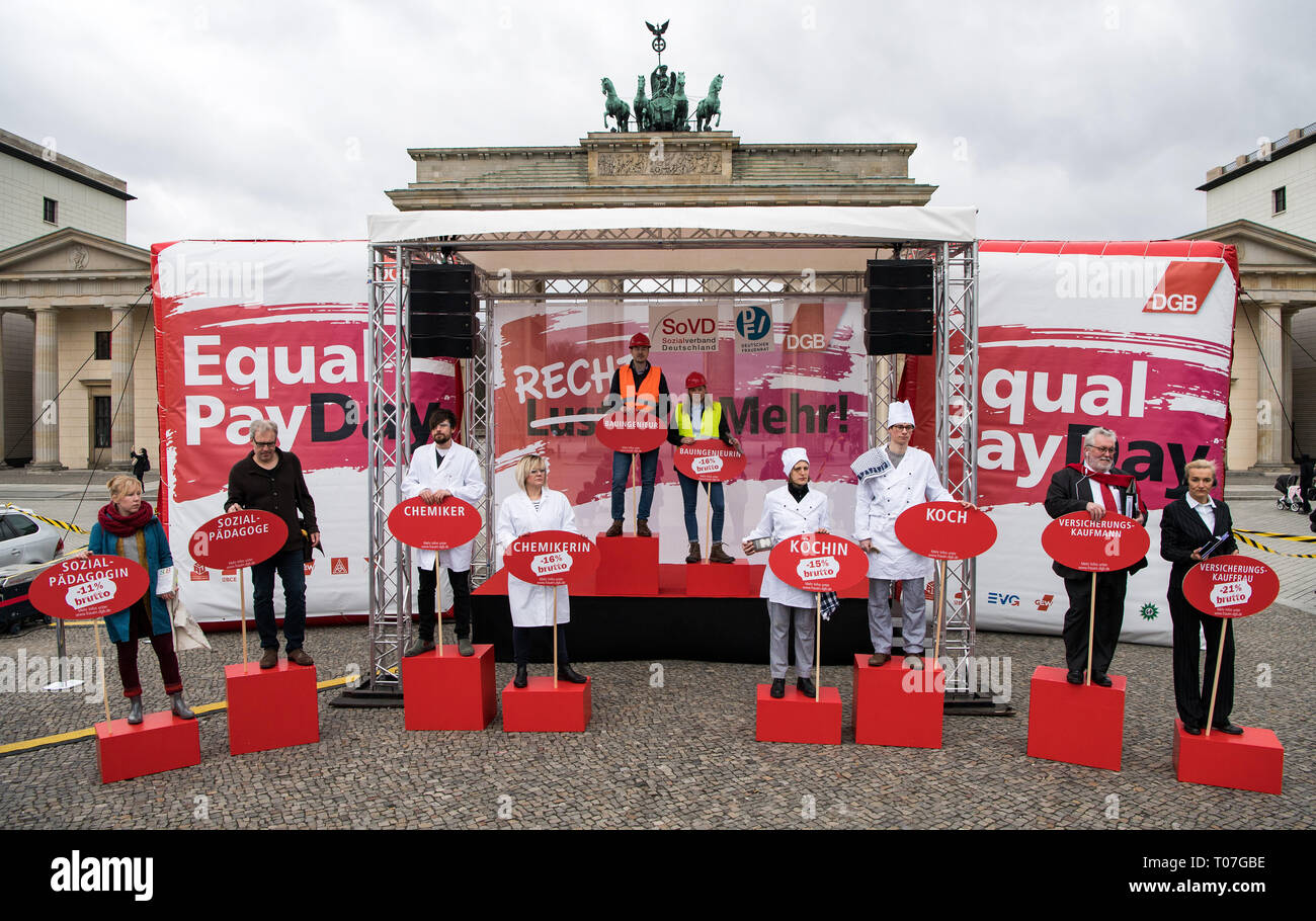 Berlino, Germania. Xviii Mar, 2019. Professional coppie mostrano le differenze retributive in corrispondenza di una azione foto in occasione di un raduno della federazione tedesca dei sindacati (DGB), il tedesco associazione sociale e il Tedesco donne del Consiglio sulla parità di retribuzione giorno' sulla Pariser Platz. Secondo i calcoli effettuati dall'Ufficio federale di statistica, donne in Germania guadagnano in media il 21 percento in meno rispetto agli uomini. La parità di retribuzione giorno' segna simbolicamente il divario retributivo tra i sessi, ossia il giorno fino a che le donne hanno lavorato senza pagare rispetto agli uomini nel corrente anno. Foto Stock