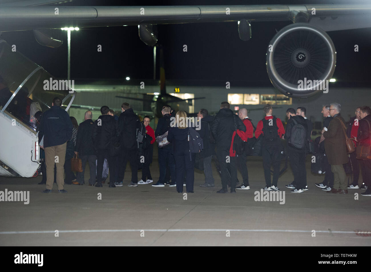 Glasgow, Regno Unito. Il 18 marzo 2019. Alex McLeish - Scozia Team Football Manager Alex McLeish (secondo da destra) e la Scozia squadra di calcio visto salire a bordo il lusso jetliner aeromobili privati nelle prime ore visto all aeroporto di Glasgow momenti prima della partenza per il Kazakistan per giocare una partita di mercoledì. Il volo è stato dovuto a prendere il via alle 23.00, tuttavia a causa di un problema imprevisto di cui il pilota doveva venire fuori il ponte di volo e sull'asfalto e parlare con il personale a terra, il volo finalmente ha preso il largo nelle prime ore di oggi. Credito: Colin Fisher/Alamy Live News Foto Stock