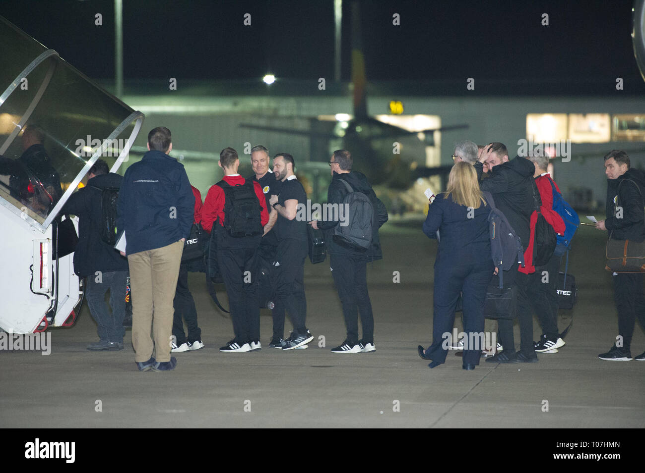 Glasgow, Regno Unito. Il 18 marzo 2019. Callum Patterson (7 da destra) e Peter Grant (estrema destra) e la Scozia squadra di calcio visto salire a bordo il lusso jetliner aeromobili privati nelle prime ore visto all aeroporto di Glasgow momenti prima della partenza per il Kazakistan per giocare una partita di mercoledì. Il volo è stato dovuto a prendere il via alle 23.00, tuttavia a causa di un problema imprevisto di cui il pilota doveva venire fuori il ponte di volo e sull'asfalto e parlare con il personale a terra, il volo finalmente ha preso il largo nelle prime ore di oggi. Credito: Colin Fisher/Alamy Live News Foto Stock