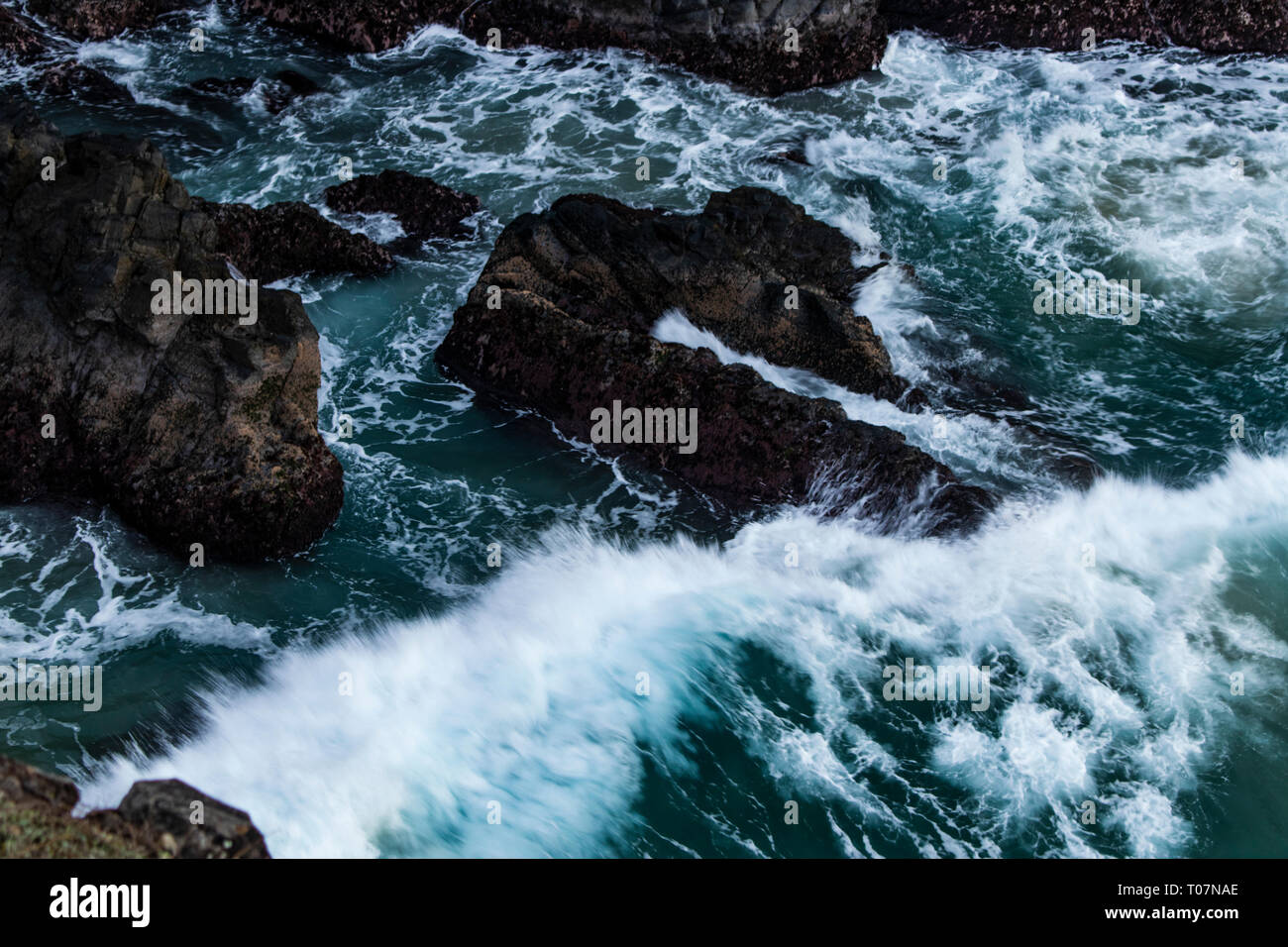 Onde che si infrangono sulle rocce Foto Stock