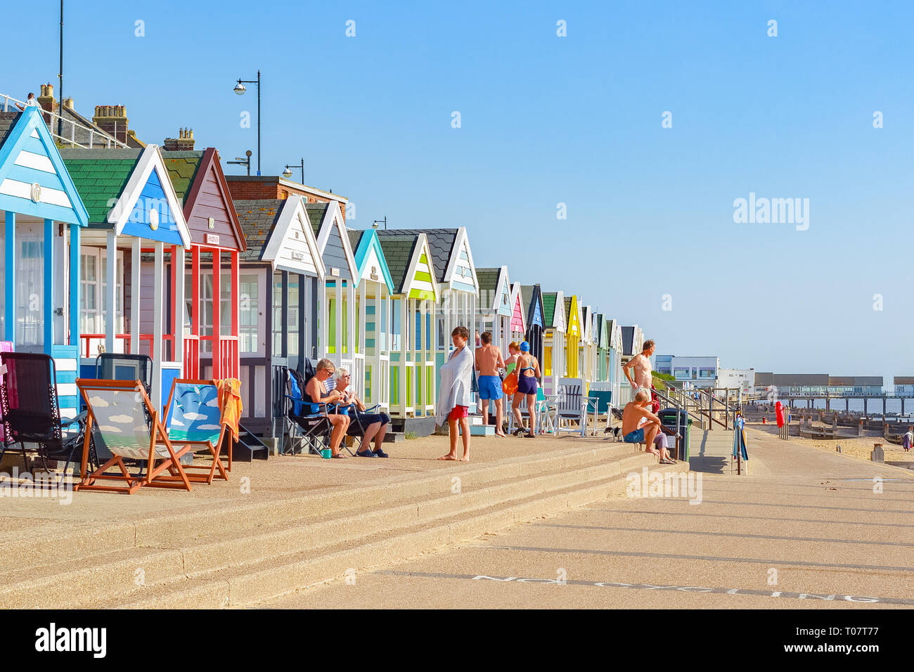 Southwold, Regno Unito - 11 settembre 2018 - Persone godendo il sole sul lungomare di Southwold Beach rivestita con una fila di cabine sulla spiaggia, Foto Stock