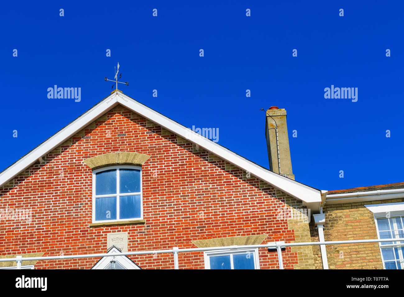 In prossimità del raccolto di un inglese casa in mattoni rossi contro un cielo blu senza nuvole Foto Stock