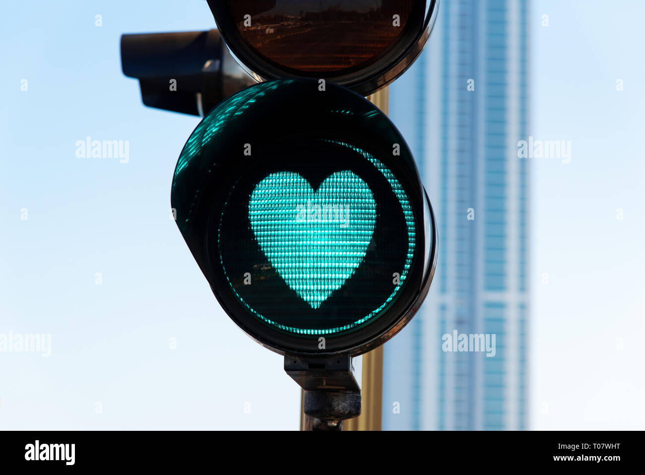 A forma di cuore la luce del traffico su strada stretta fino Foto Stock