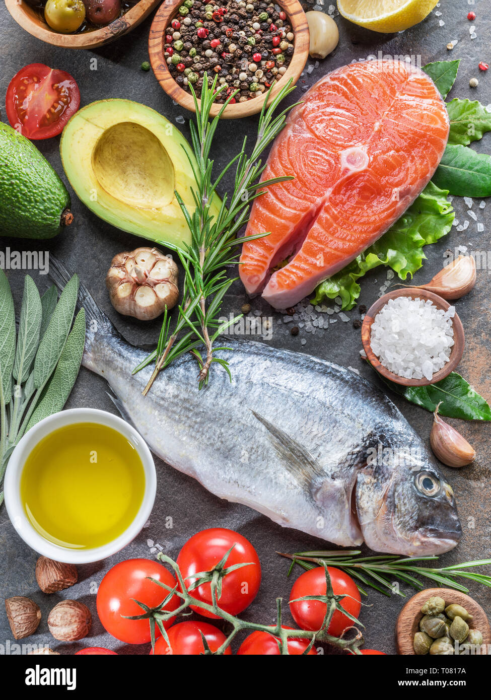 Materie dorado pesce e bistecca di salmone con spezie e verdure sulla scheda di grafite. Vista dall'alto. Foto Stock