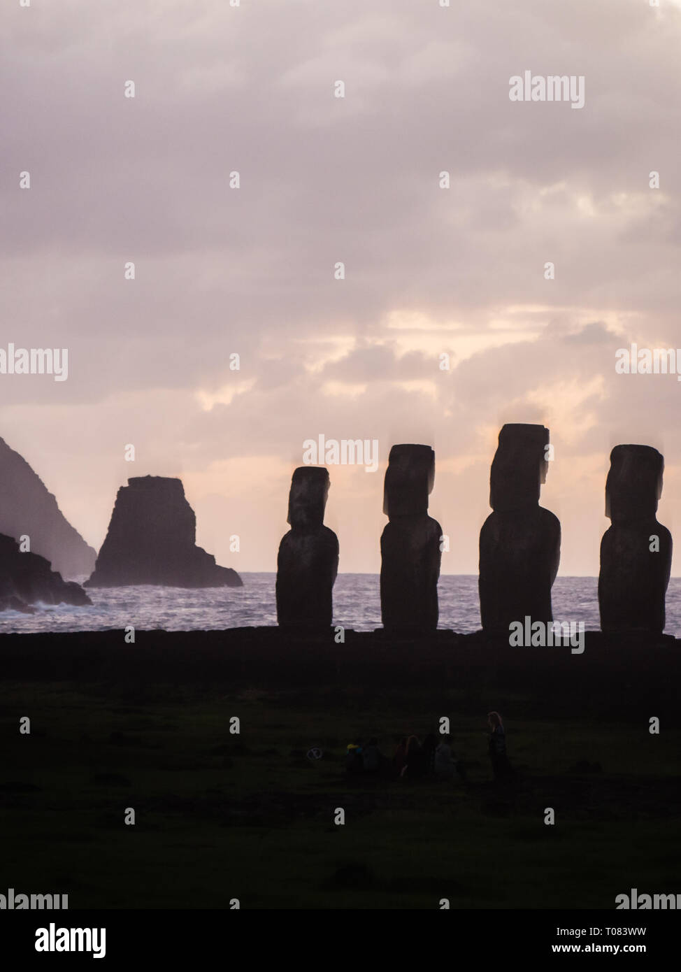 Sunrise a Ahu Tongariki con il motu sul retro, silhouette di sei fifthteen moais Foto Stock