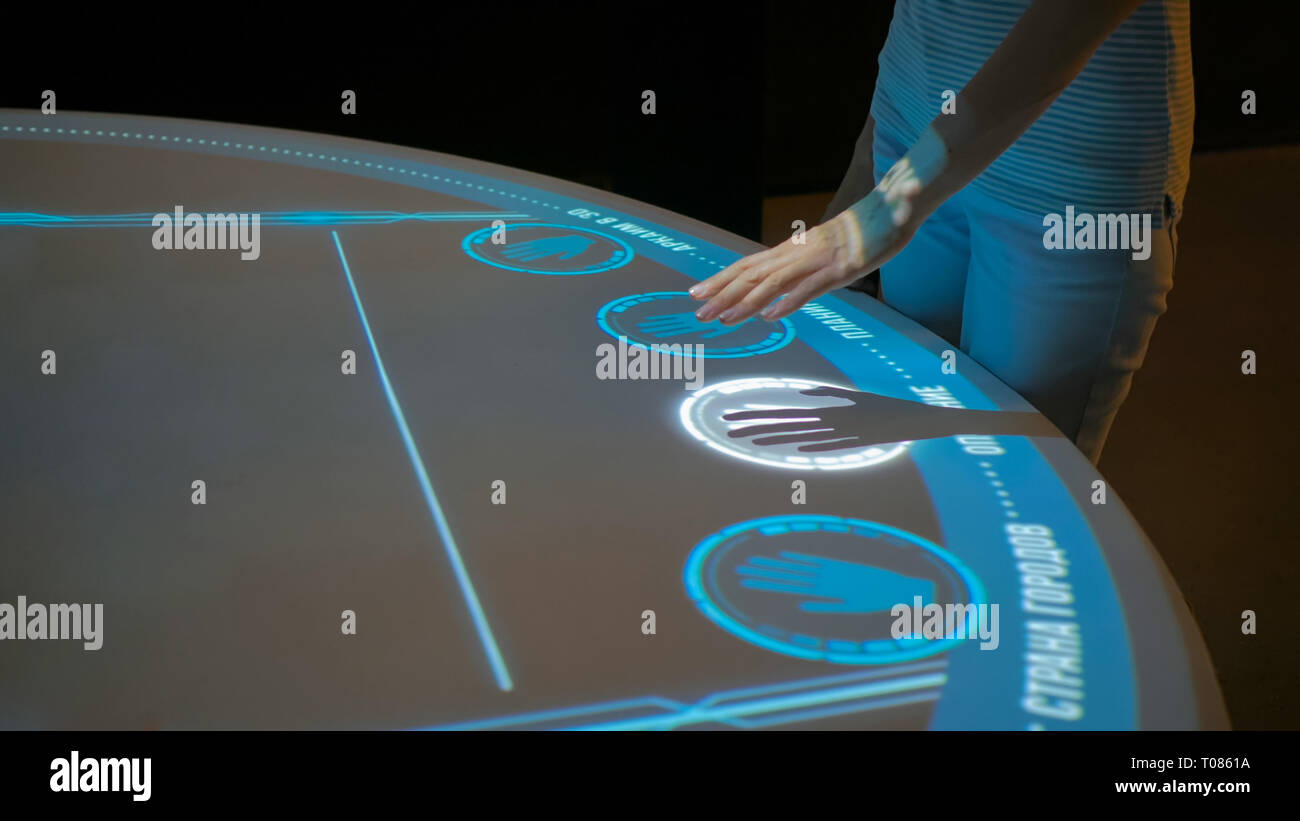 Donna che utilizza la visualizzazione interattiva senza toccare la tecnologia di controllo Foto Stock