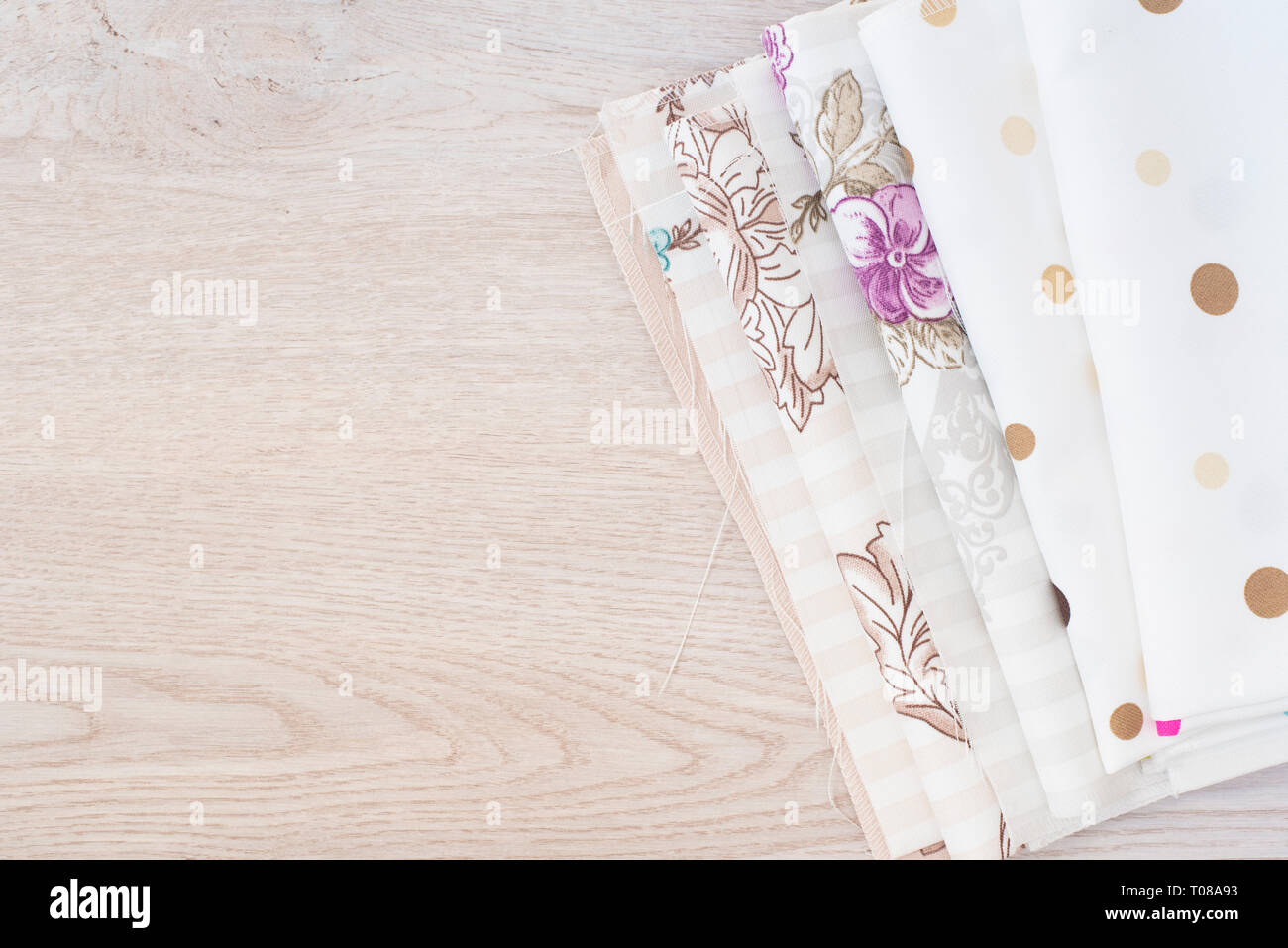 Mucchio di stoffa tessuti su legno grigio Sfondo, vista dall'alto Foto Stock