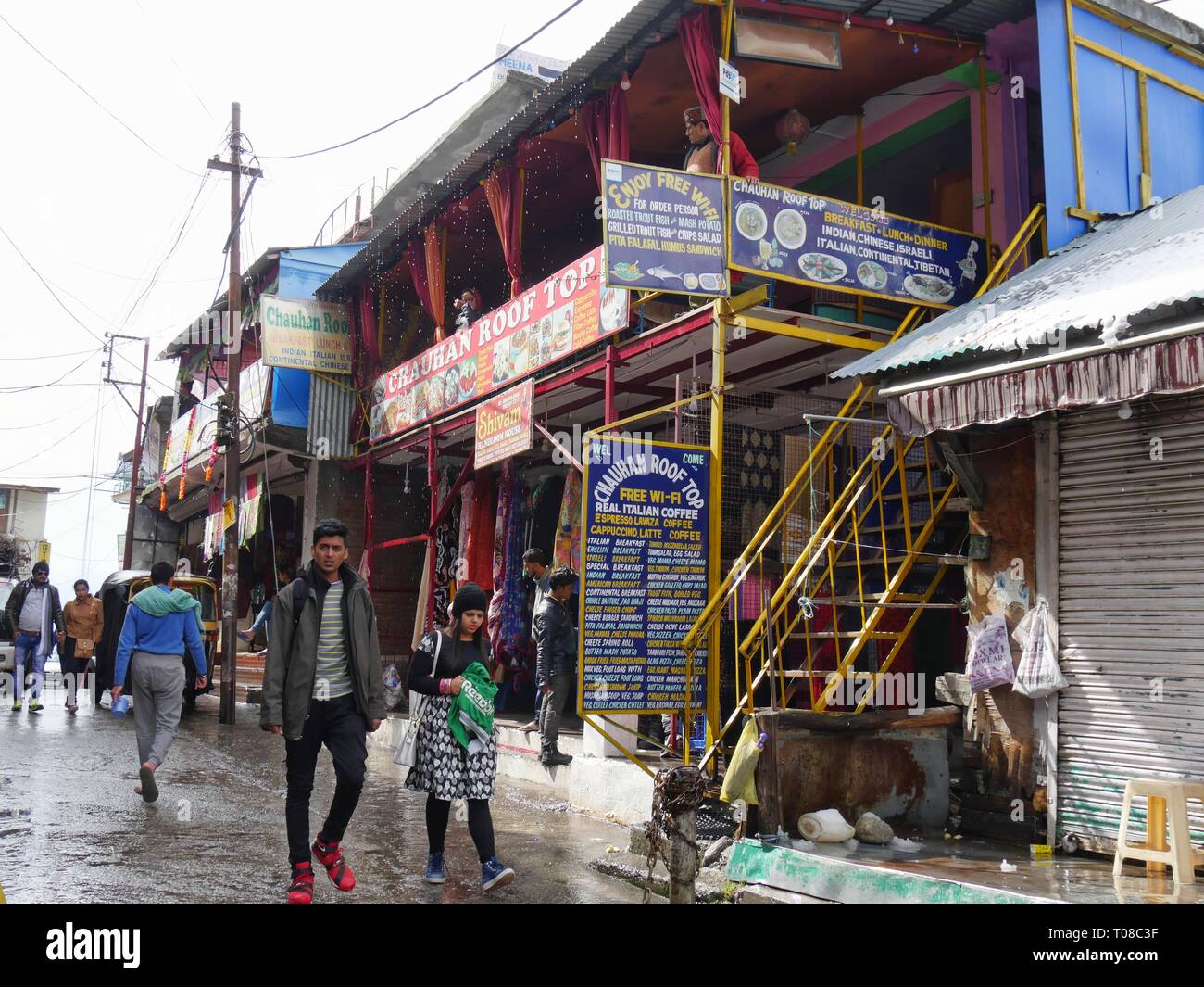 MANALI, HIMACHAL PRADESH, INDIA-MARZO 2018: Scena di strada tipica con negozi di strada a Manali in una fredda mattina piovosa. Foto Stock