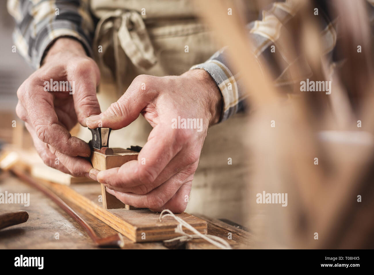 Le mani di uno strumento maker lavorando su un arco di violino Foto Stock