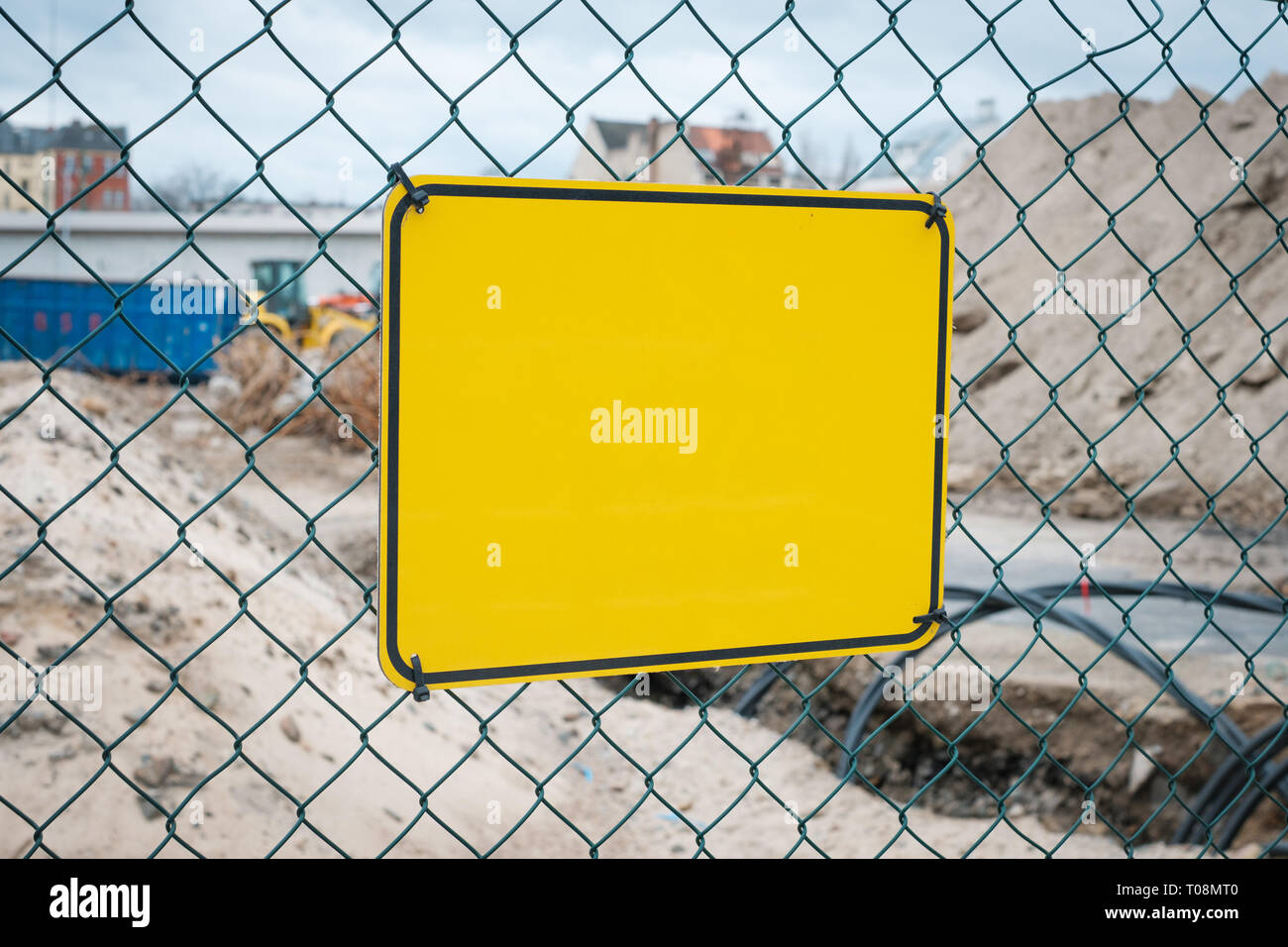 Vuoto segno giallo sul sito in costruzione recinto - segno di avvertimento mock-up Foto Stock