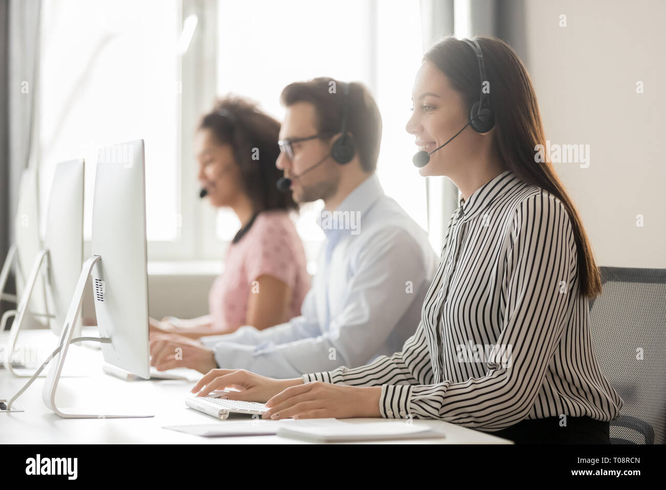 Call center agent in cuffia lavorare in ufficio customer care Foto Stock