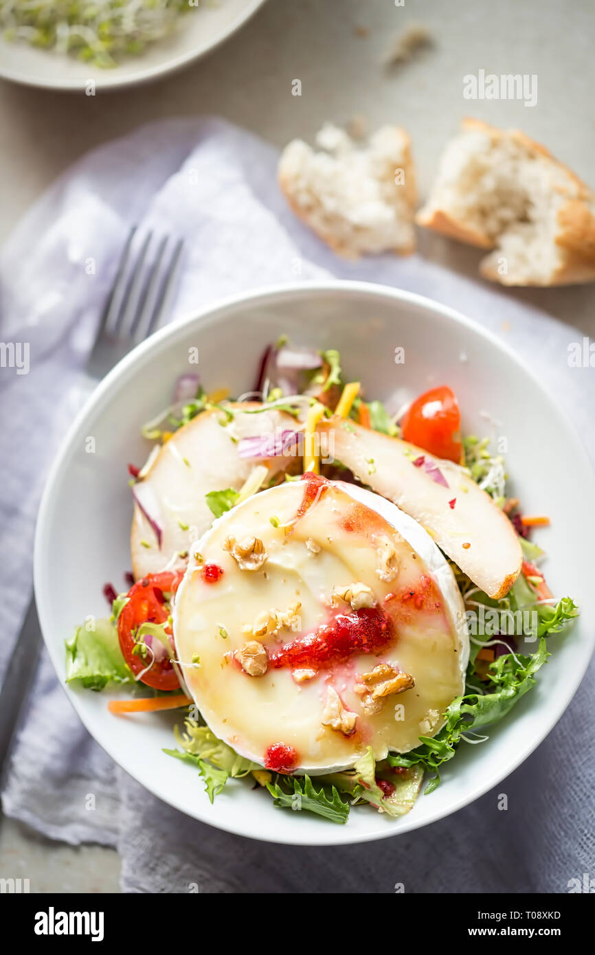 Con insalata di lattuga, Pere fritte, camembert, noci, cipolla rossa, pomodori e lampone vinaigrette dressing Foto Stock