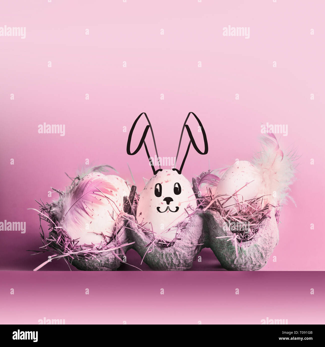 Coniglietto di pasqua coniglio dipinta su uova a pastello sfondo rosa Foto Stock