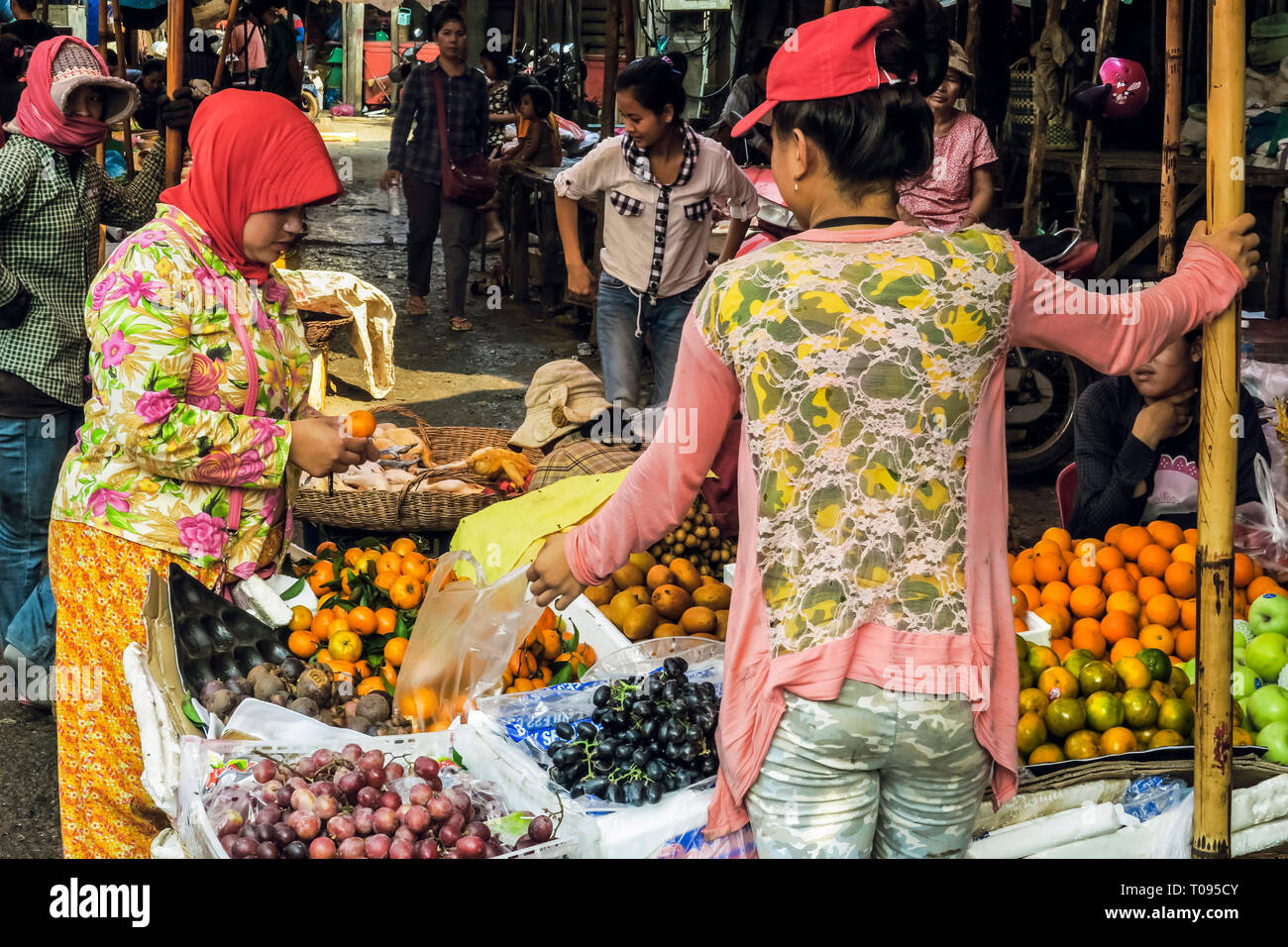 Shopper & produttore presso un frutto in stallo il Psar Chas Vecchio Mercato nel centro di Siem Reap, il nord ovest della città turistica; Siem Reap, Cambogia Foto Stock