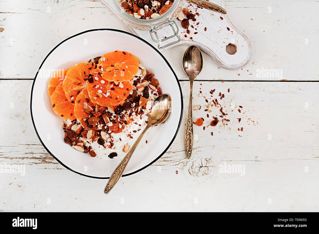 Ciotola di muesli fatti in casa con yogurt e mandarino bianco su un tavolo di legno. Cibo per il fitness. Vista superiore Foto Stock