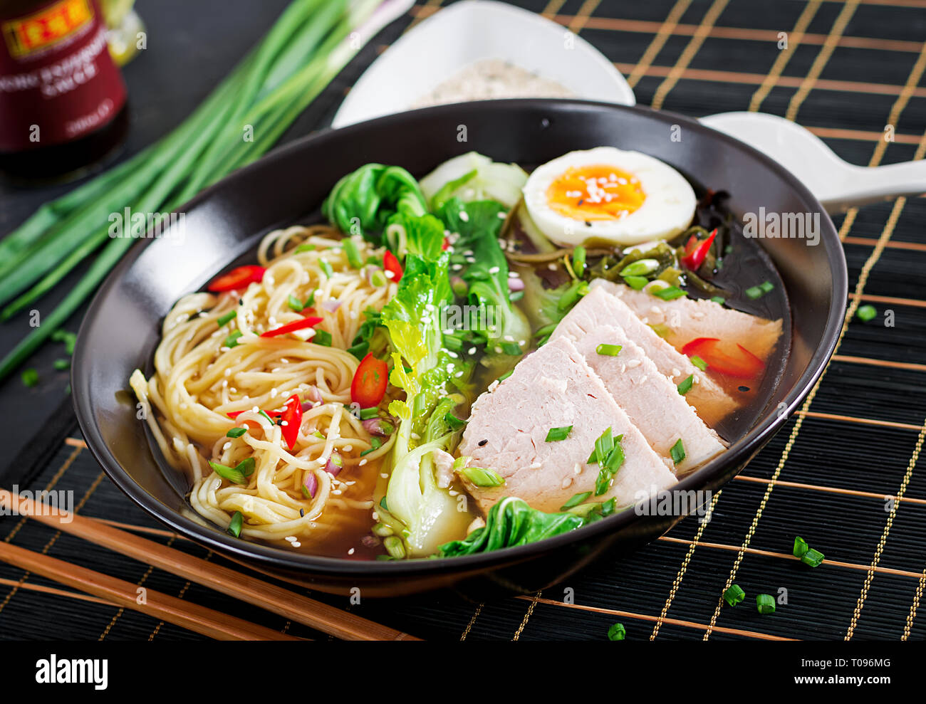 Miso Ramen Asian Tagliatelle con uova, carne di maiale e di pak choi cavolo in ciotola su sfondo scuro. La cucina giapponese. Foto Stock