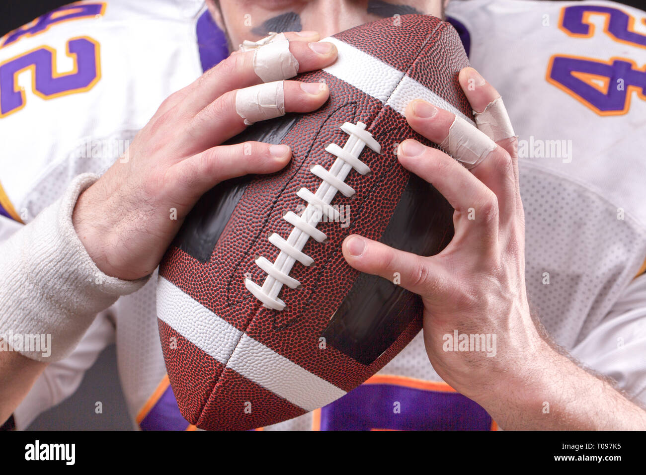 Immagine ritagliata di sportivo tenendo il football americano la sfera Foto Stock