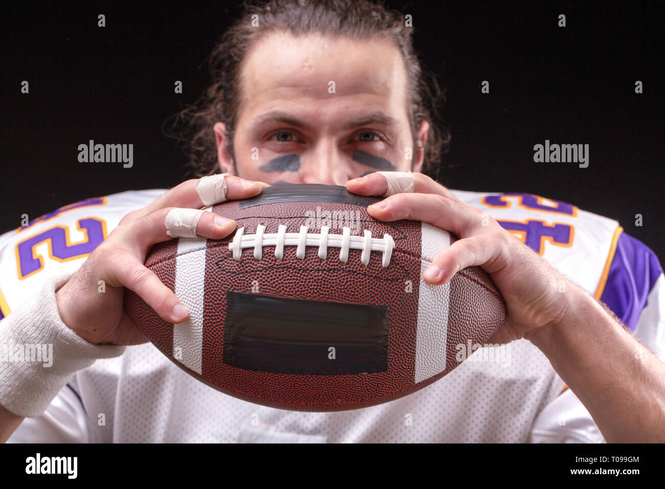 Immagine ritagliata di sportivo tenendo il football americano la sfera Foto Stock
