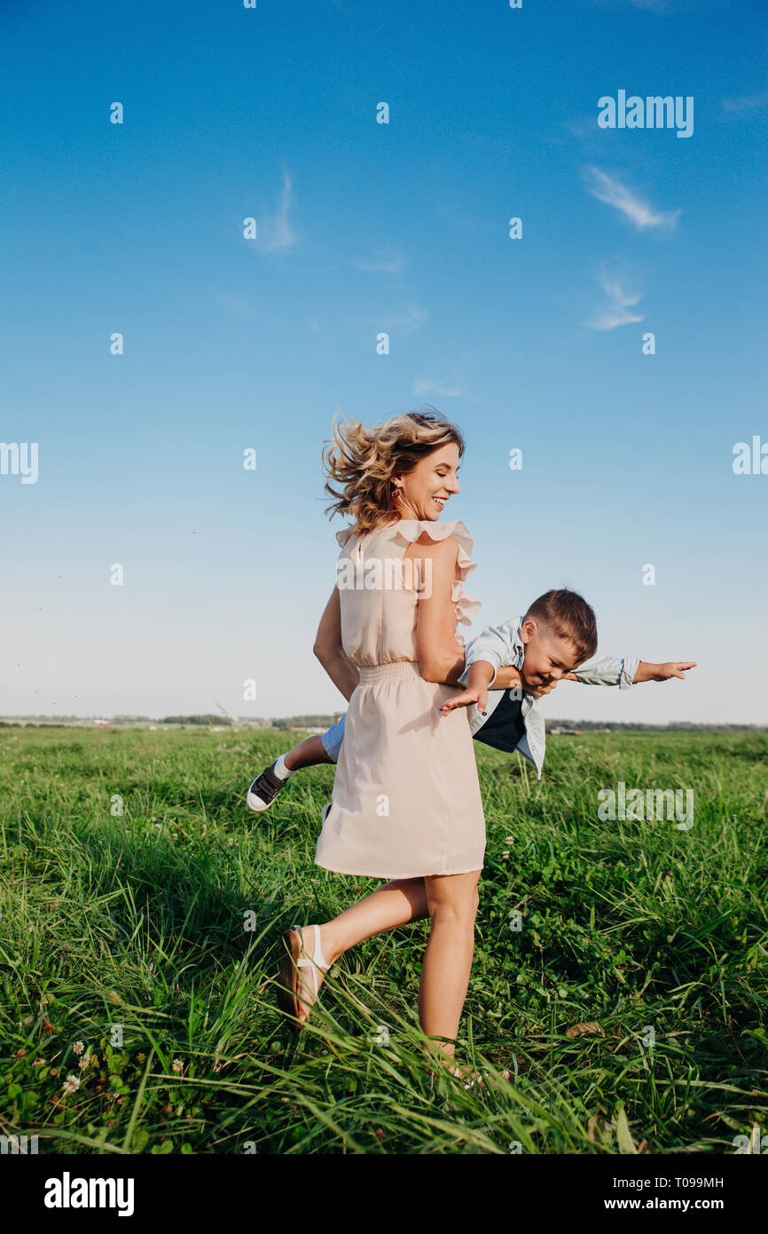 Donna felice con bambini che giocano insieme nel campo Foto Stock