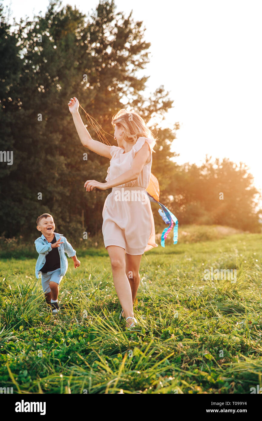 Donna felice con bambini che giocano insieme nel campo Foto Stock