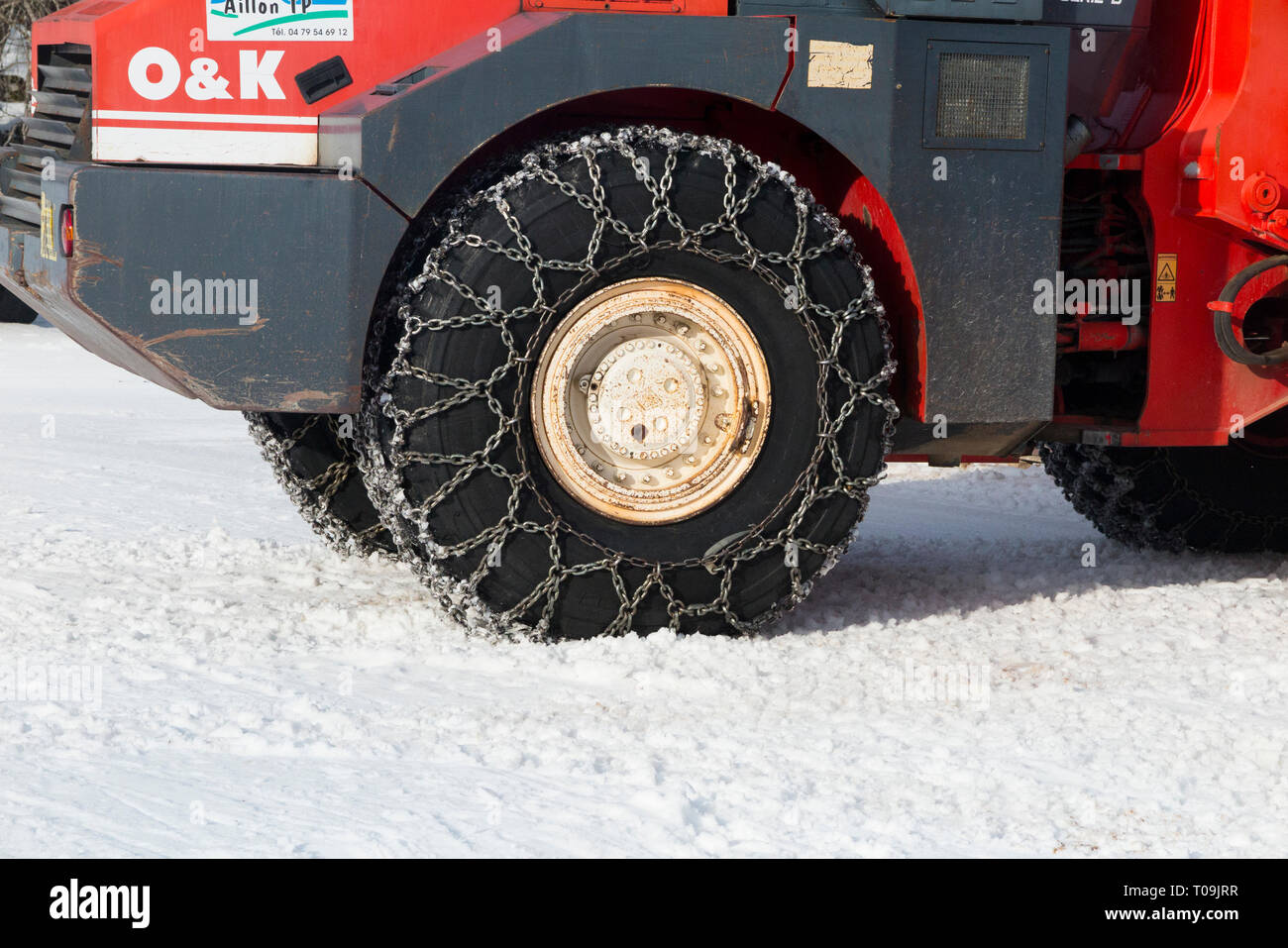 Catena da neve / catene su fronte e retro / ruota posteriore / Ruote / Pneumatici / pneumatici di un agricolo veicolo commerciale, caricatore su ruote / trattore nel gelido inverno meteo con caduta neve & ghiaccio congelato. (104) Foto Stock