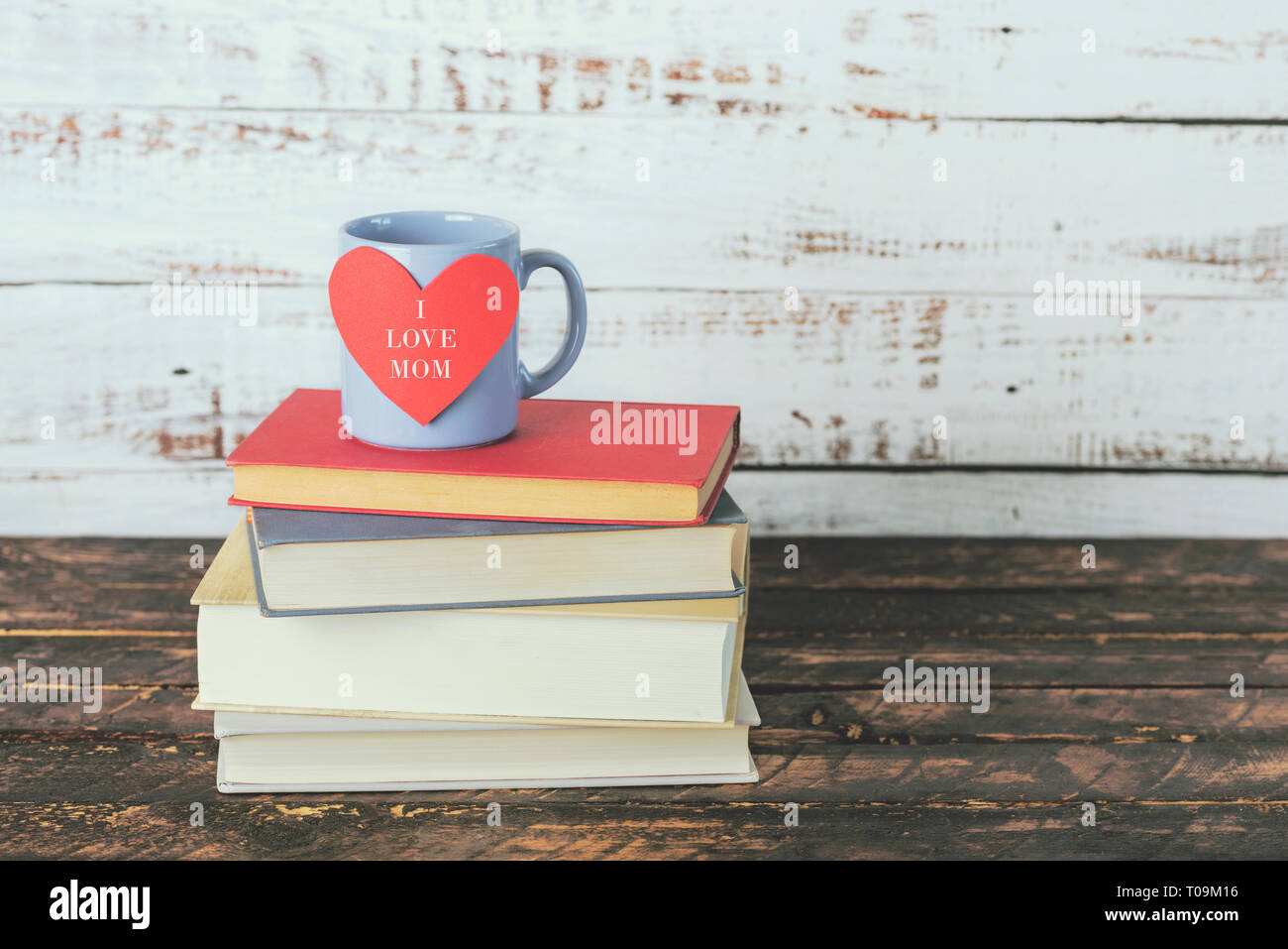 Io amo mamma, libri accanto a una tazza di caffè su di un tavolo di legno Foto Stock