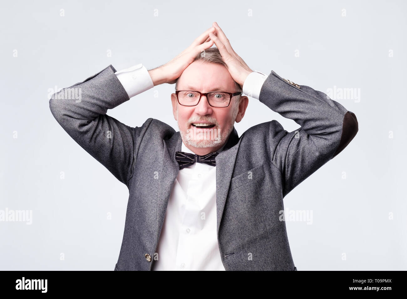 Uomo con scioccato, stupito espressione isolato su sfondo grigio Foto Stock