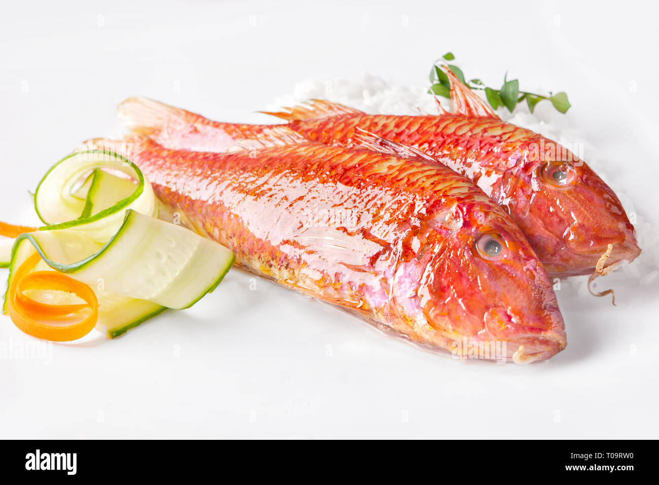 Due triglie e verdure su sfondo bianco Foto Stock