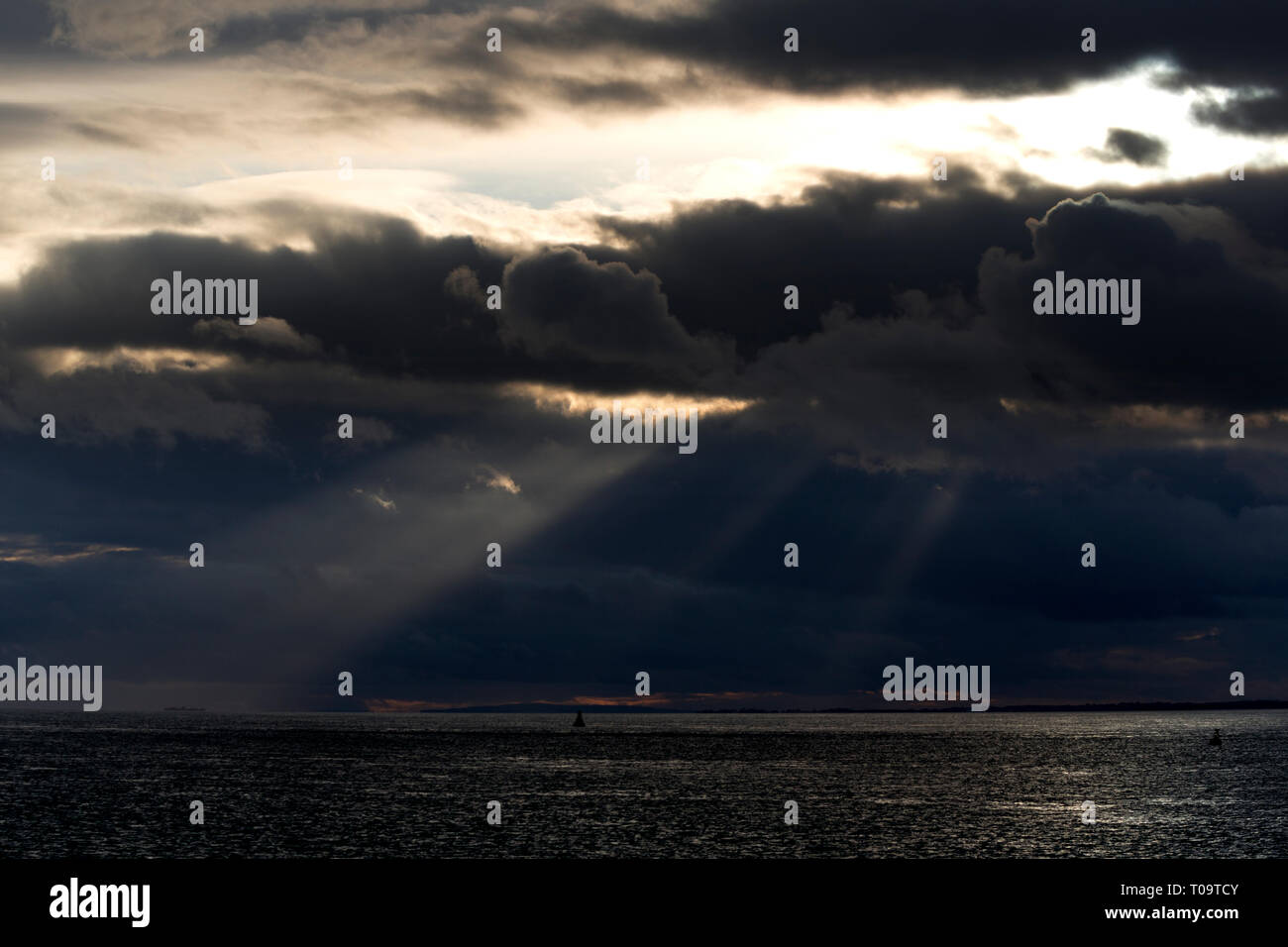 Luce,travi,attraverso,nuvole,oltre,mare,Il Solent,Cowes,Grondin,Isle of Wight, England, Regno Unito Foto Stock