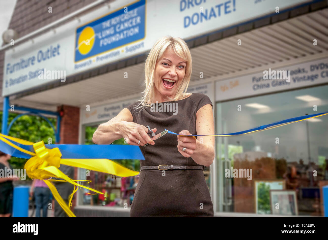 L'attrice Terri Dwyer taglia un nastro in un negozio l'apertura. Foto Stock