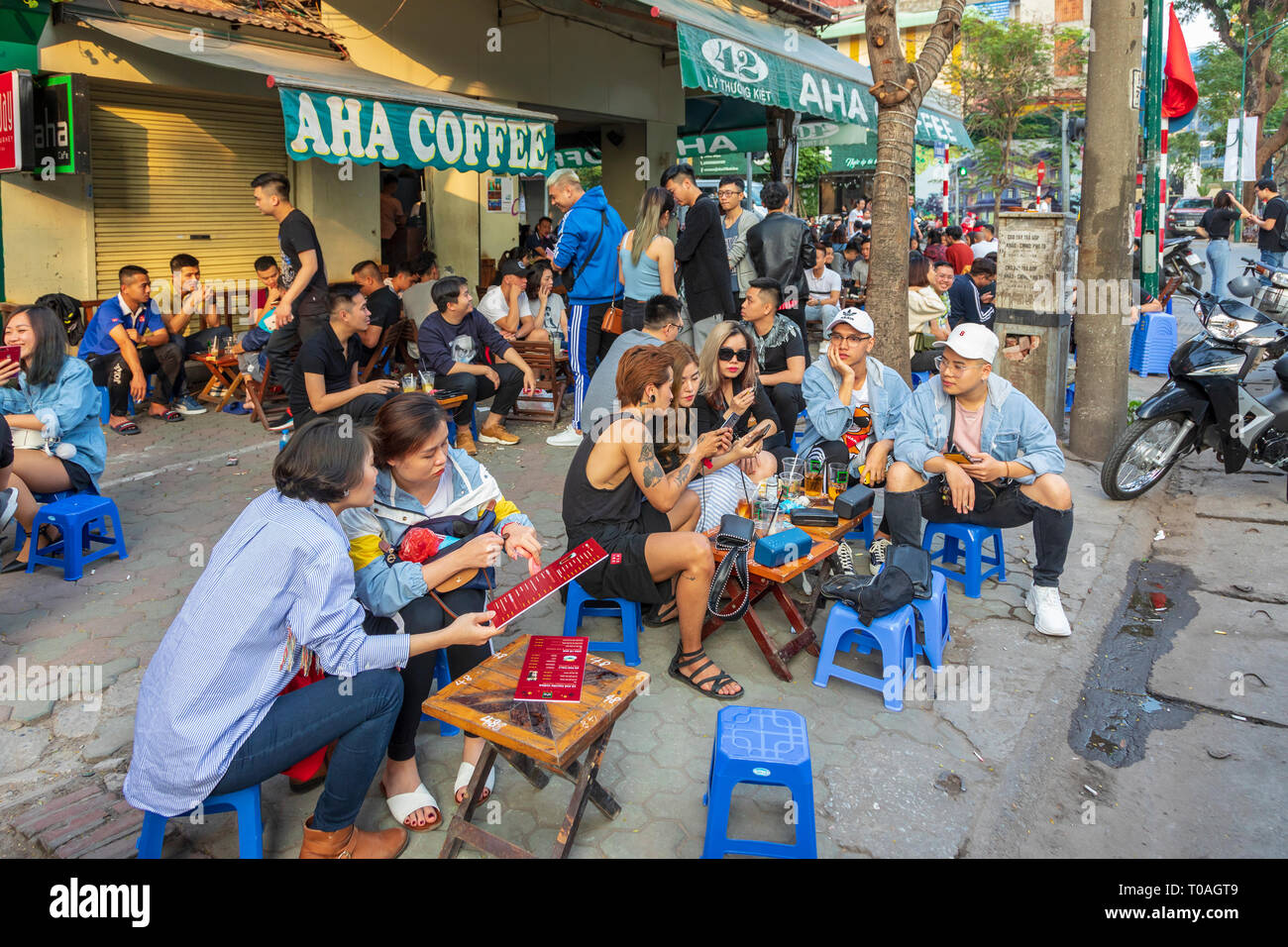 I giovani studenti con caffè e bevande a street cafe, il vecchio quartiere di Hanoi, Vietnam Asia Foto Stock