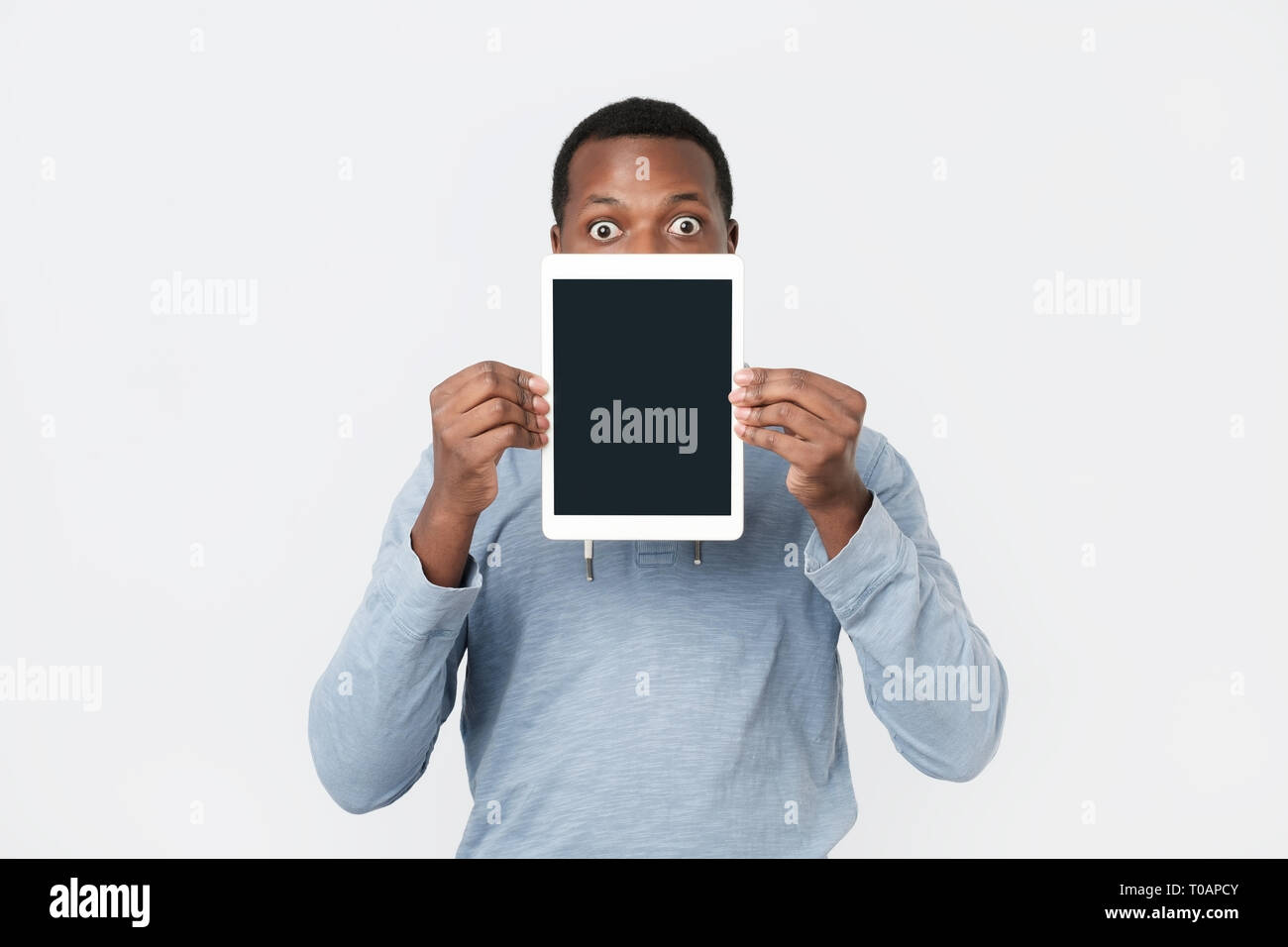 Giovane africano con la compressa che mostra lo schermo del tablet PC moderni. Foto Stock