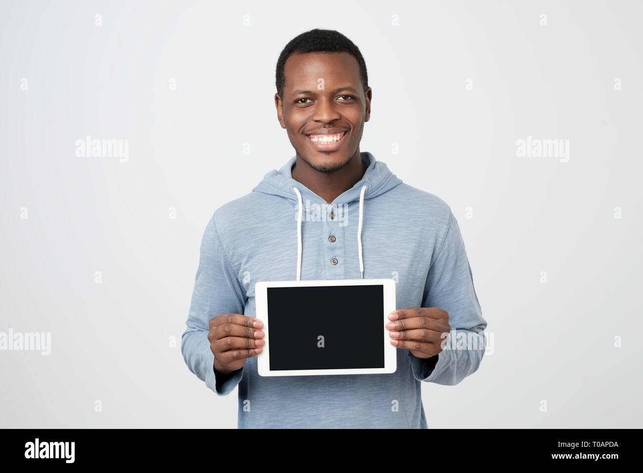 Giovane africano con la compressa che mostra lo schermo del tablet PC moderni. Foto Stock