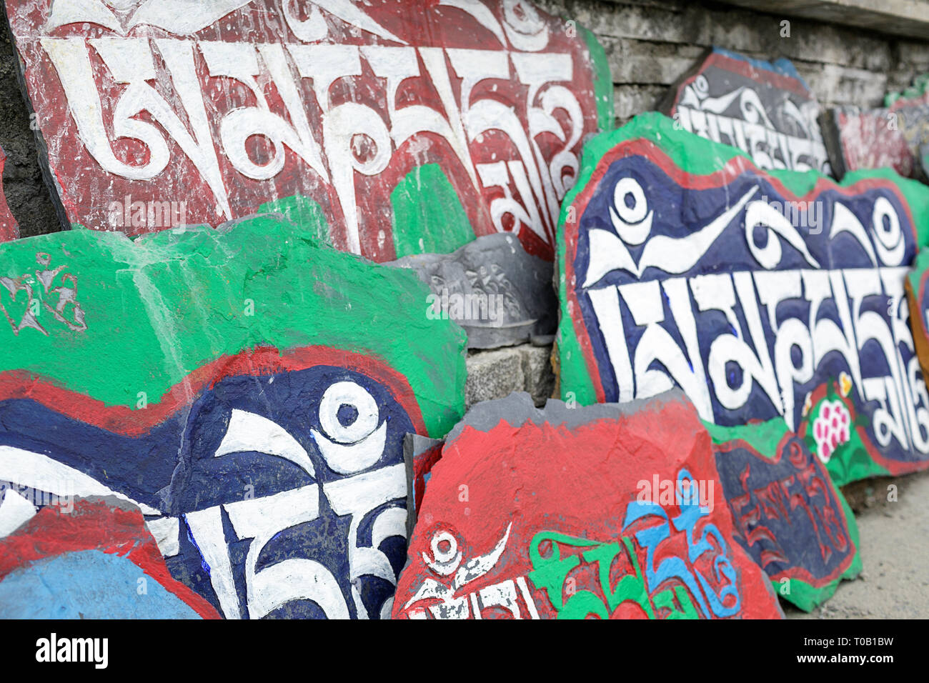 Mani lungo muro di pietra, Tagong, Sichuan, in Cina Foto Stock