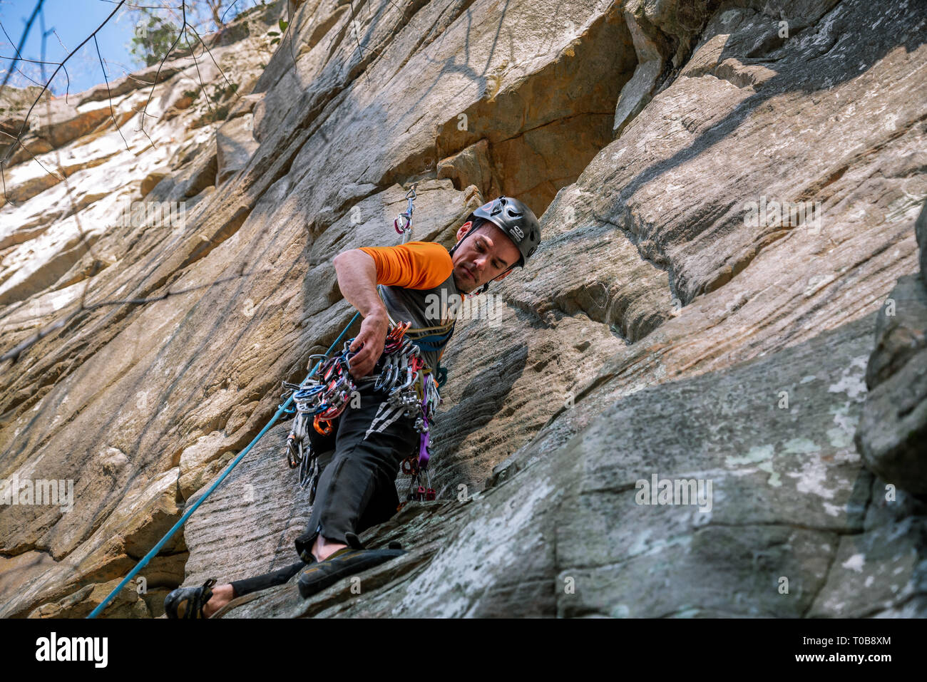 Un giovane uomo si arrampica e ordina attraverso la sua marcia mentre trad climbing in Obed selvaggio nazionale e Scenic River. Foto Stock