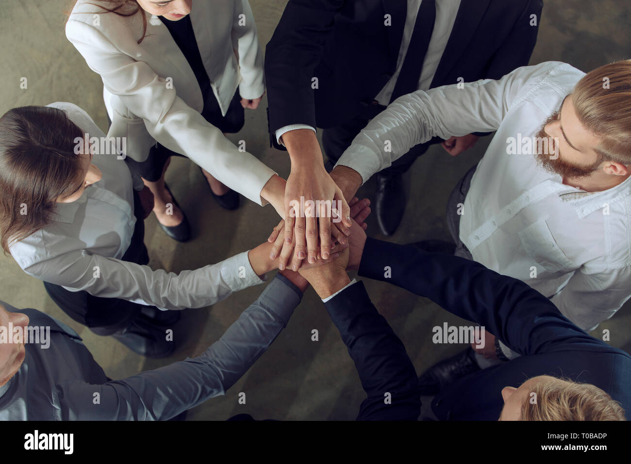 La gente di affari di mettere le loro mani insieme. Concetto di integrazione, il lavoro di squadra e la collaborazione. Foto Stock
