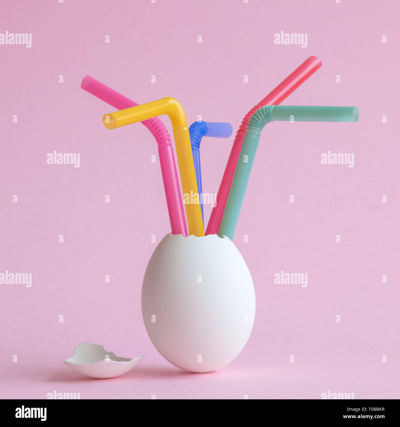 Bianco con uova colorate cannucce potabile sul rosa pastello background creativo minima nozione di pasqua. Foto Stock