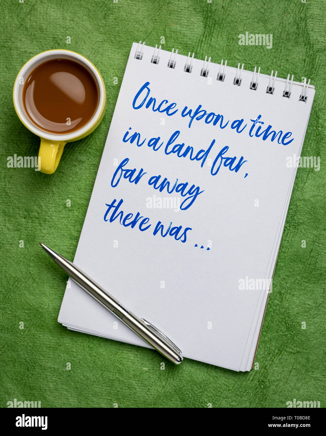 Una volta in una terra lontana - una frase di apertura di narrazioni orali, storia o favola scritta a mano in un'arte sketchbook con una tazza di caffè Foto Stock