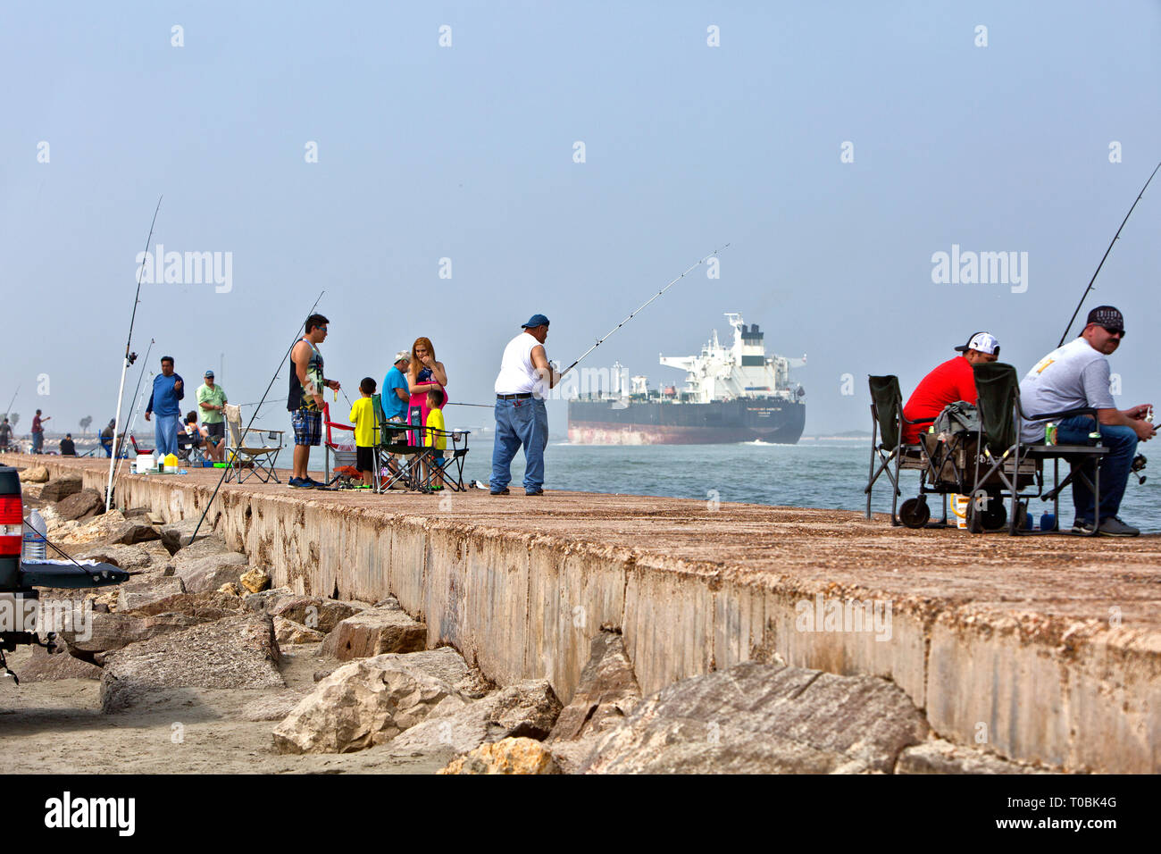 Famiglie con i figli piccoli, pescatori, pesca a Port Aransas Jetty Port Aransas molo che si estende a sud verso il Golfo del Messico. Foto Stock