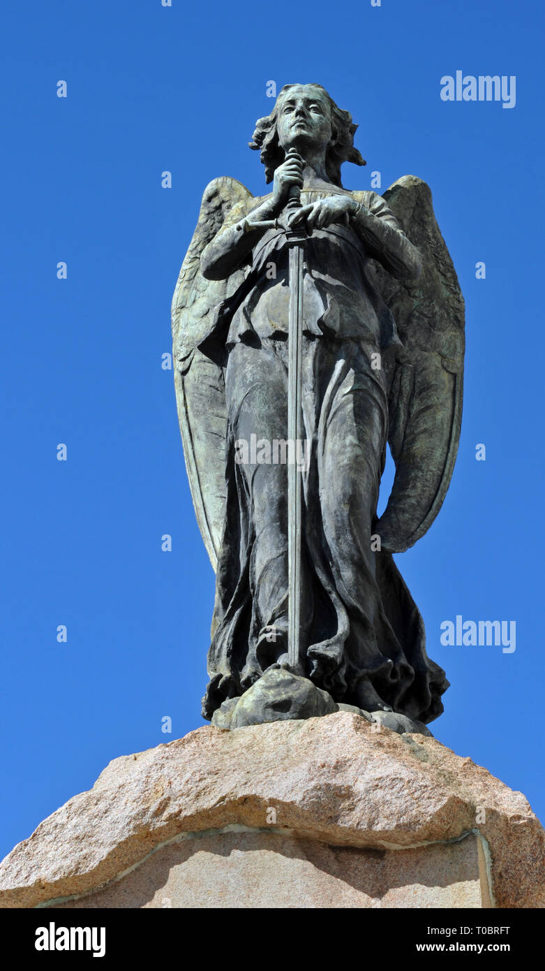 Una scultura di un angelo alato che tiene una spada sorge sulla sommità di un monumento nel centro storico cimitero di Colon (Cementerio de Cristóbal Colón) a l'Avana, Cuba. Foto Stock Una scultura di un angelo alato che tiene una spada sorge sulla sommità di un monumento nel centro storico cimitero di Colon (Cementerio de Cristóbal Colón) a l'Avana, Cuba. Foto Stock