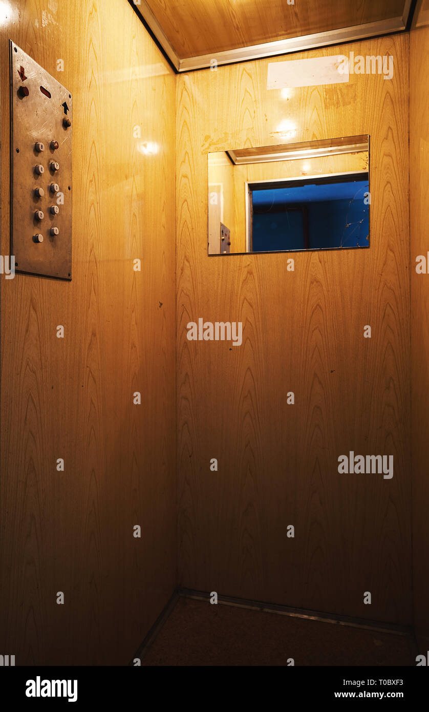 Piccolo e vecchio ascensore interno, dettagli di pulsanti di comando e pareti. Foto Stock