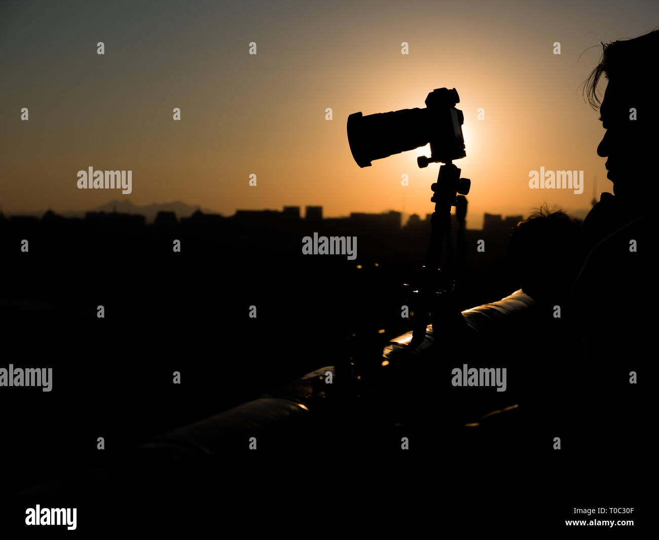 Silhouette di fotocamera e fotografo asiatici al Parco Jingshan con Pechino skyline di sfondo nella luce del tramonto, Cina Foto Stock