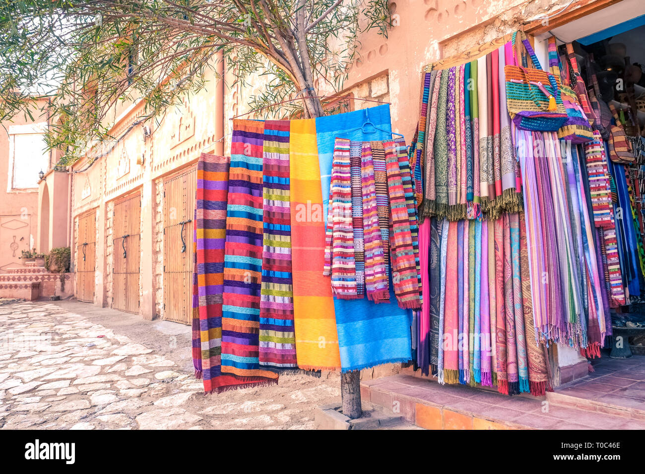 Colorate marocchine tradizionali sciarpe e scialli appeso a un albero per la vendita in un negozio di souvenir di Ouarzazate, Marocco. Foto Stock