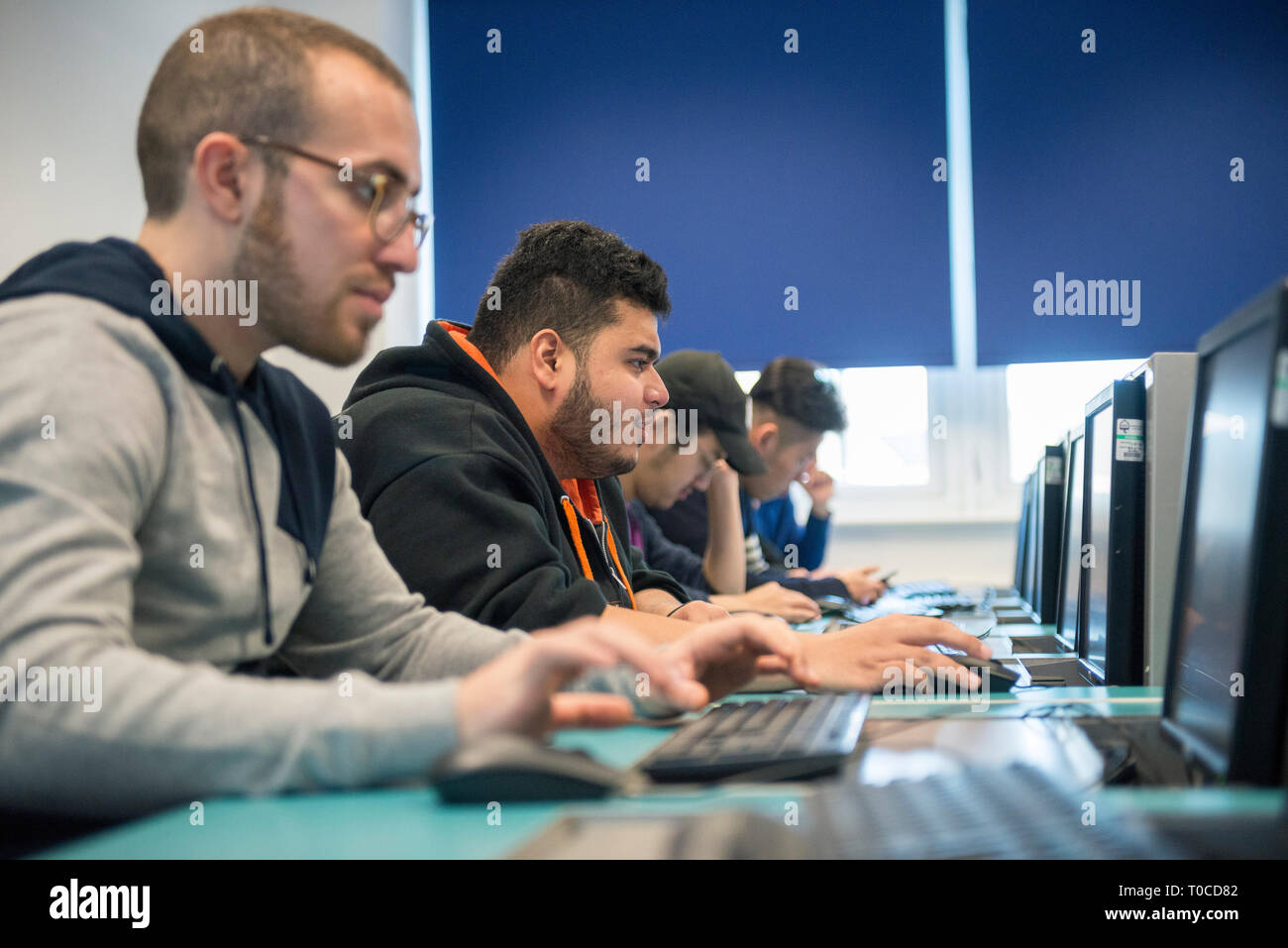 Gli studenti internazionali e gli alunni nella stanza del computer di un College / Università studiare e tramite il computer desktop Foto Stock