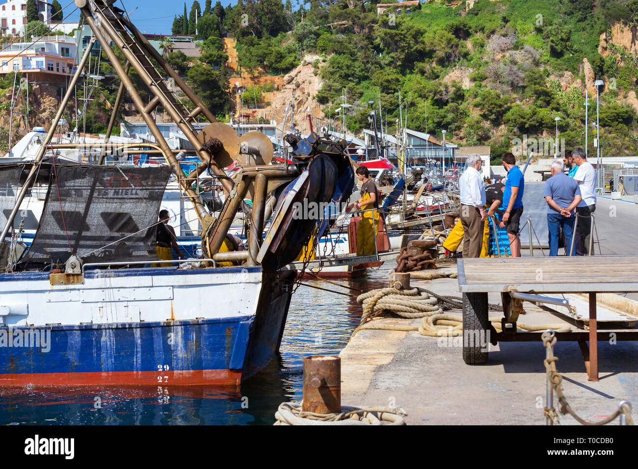 Blanes, Spagna - 31 maggio 2018: Pesca barche e yacht ormeggiati al molo nel porto Blanes. Pescatori scaricano delle catture di pesce di mare, ostriche, calamari, mare delicaci Foto Stock