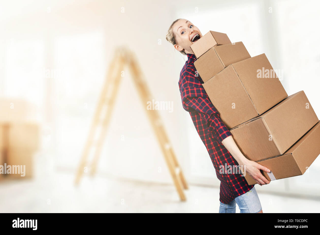 La donna si spostano in un nuovo appartamento azienda pila di scatole di cartone Foto Stock