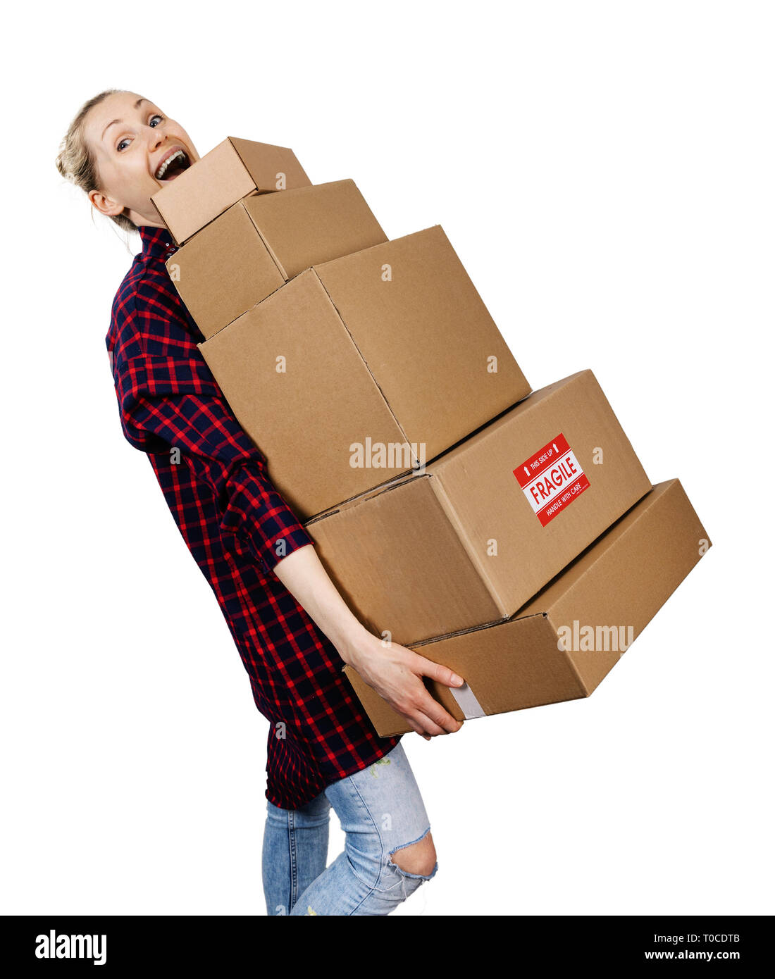 Giovane donna che porta pila di cartone pesante scatole isolato su bianco Foto Stock