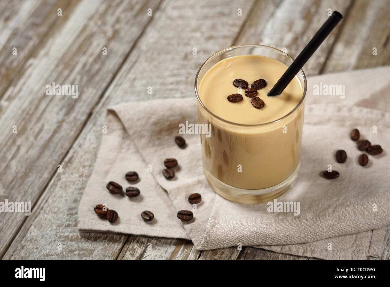 Caffè freddo Crema frullato frullato di drink in un ripiano in vetro con i chicchi di caffè su una tavola di legno tavolo rustico con copia spazio. Foto Stock