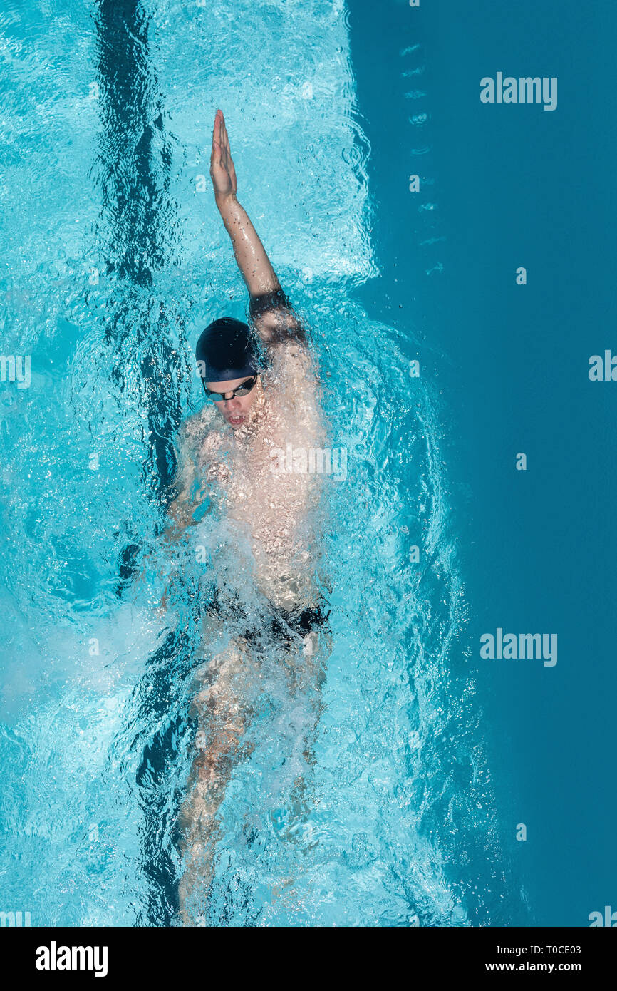 Giovani nuotatore nuoto dorso in piscina Foto Stock
