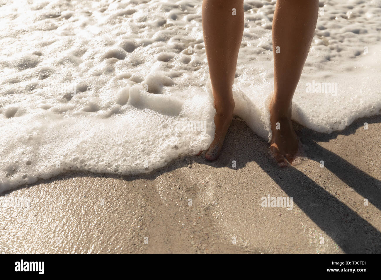 La donna caucasica conciate in piedi presso la spiaggia in una giornata di sole Foto Stock